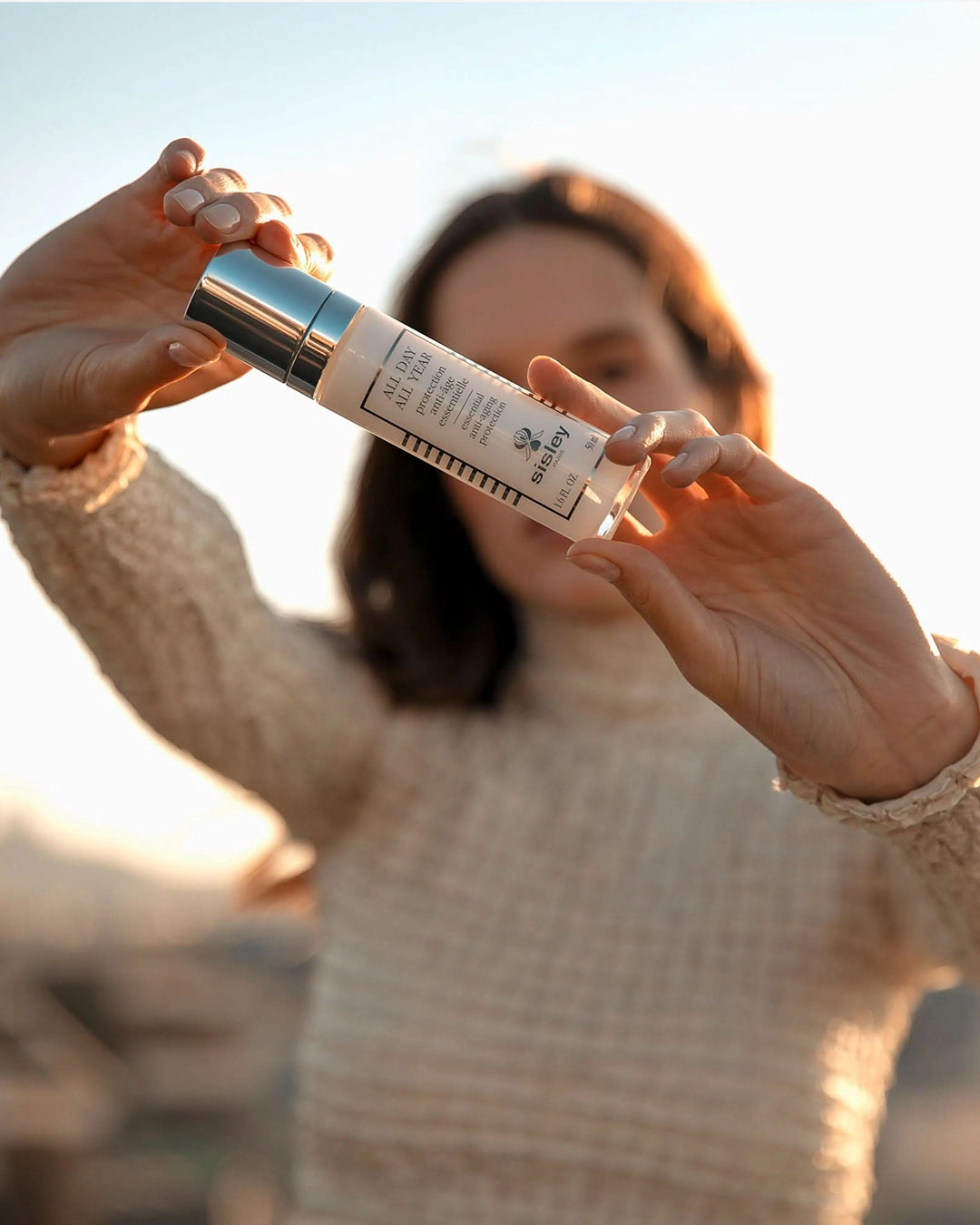 Person holding a skincare product with a blurred background