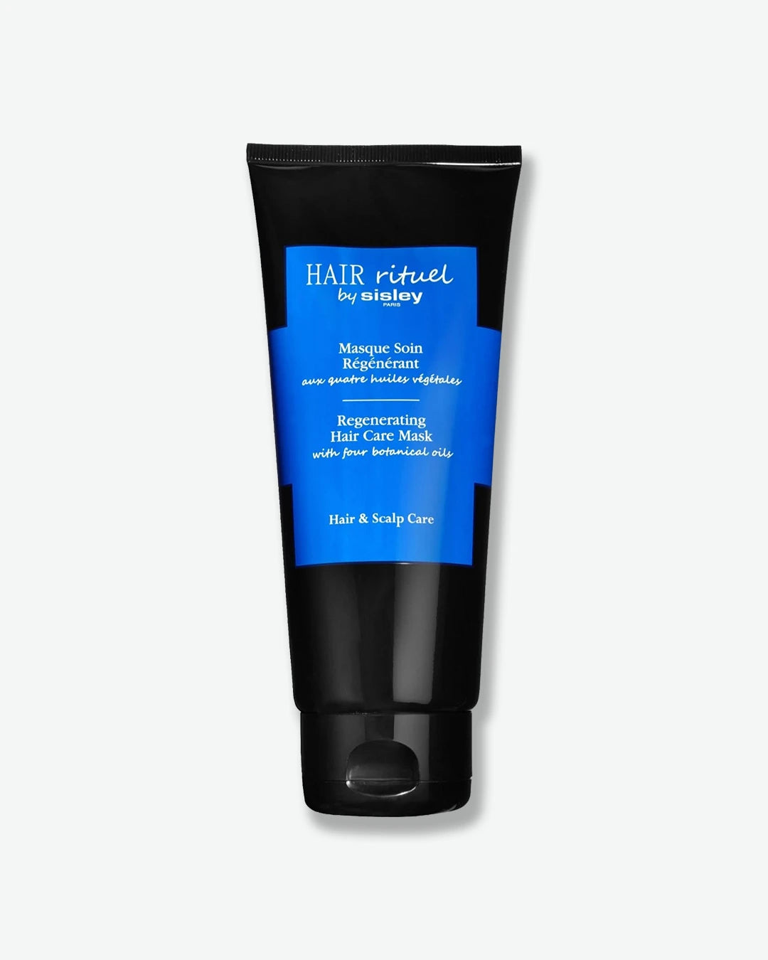 A glossy black squeeze tube of Hair Rituel by Sisley Regenerating Hair Care Mask, featuring a vibrant, solid blue cross-shaped label design on the front.
