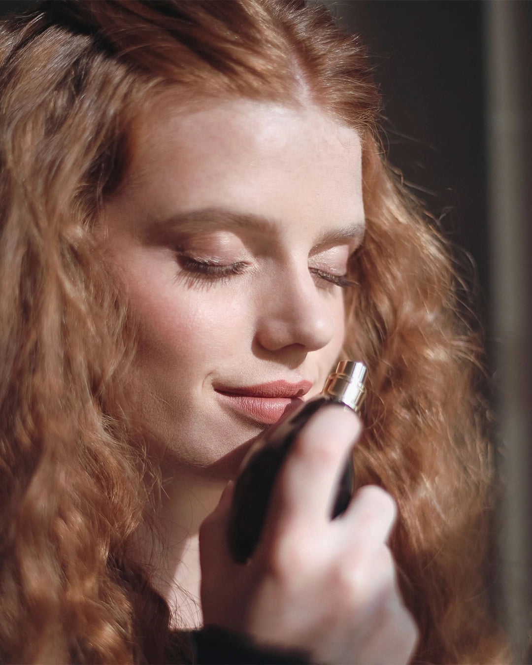 Woman smelling sisley perfume in a close-up shot