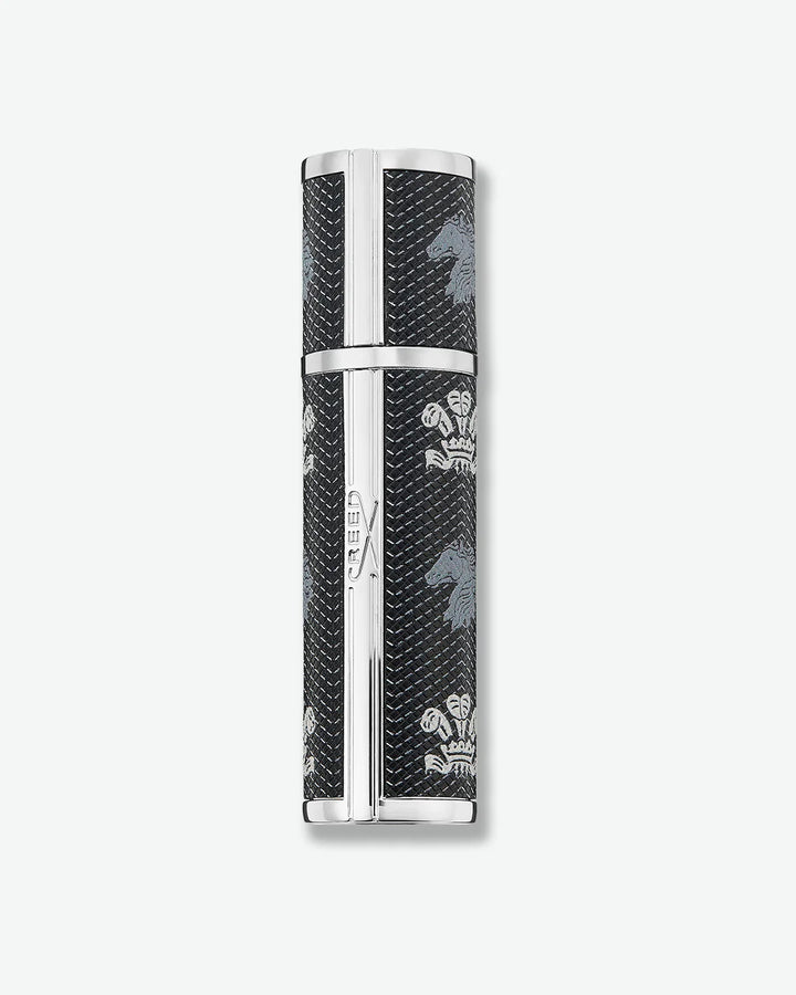 Backside view of black cylindrical Creed fragrance travel atomizer with textured leather-like finish, silver-tone metal accents, and repeating Creed logo and horse emblem on a light gray background.