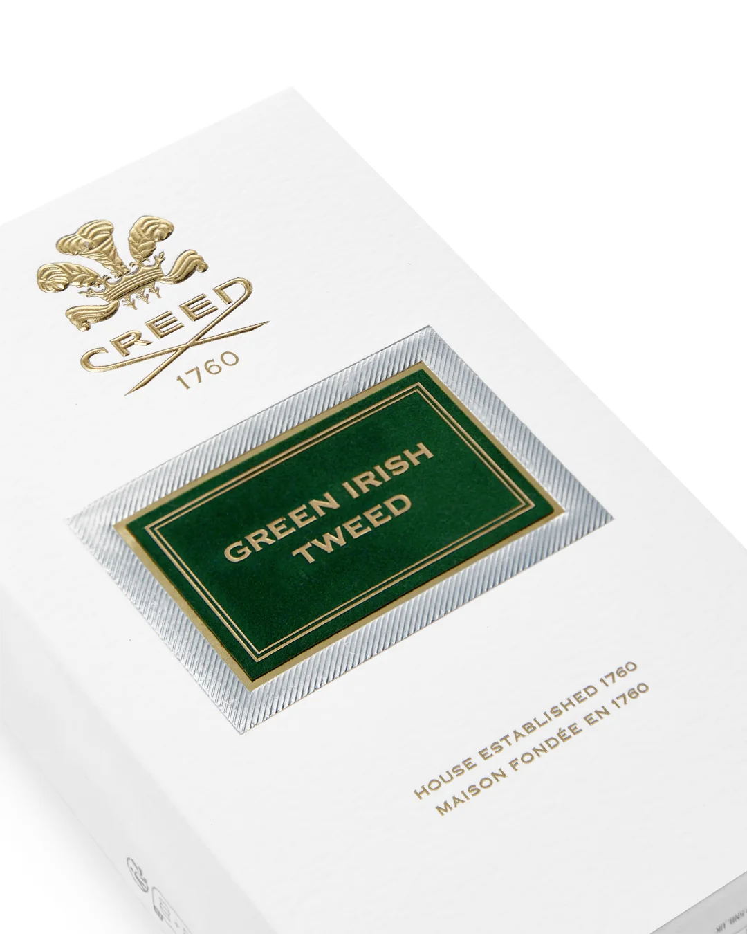 Close-up of white Creed Green Irish Tweed packaging box with gold logo and green and gold label on a white background 