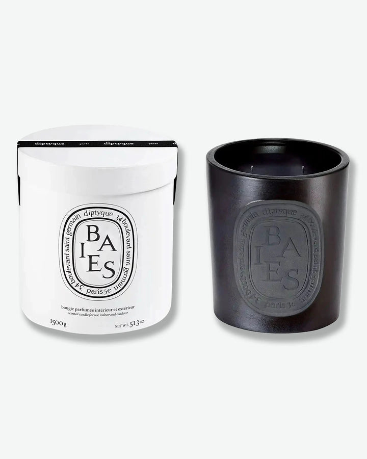 Black candle and packaging with 'Diptyque' branding on a white background