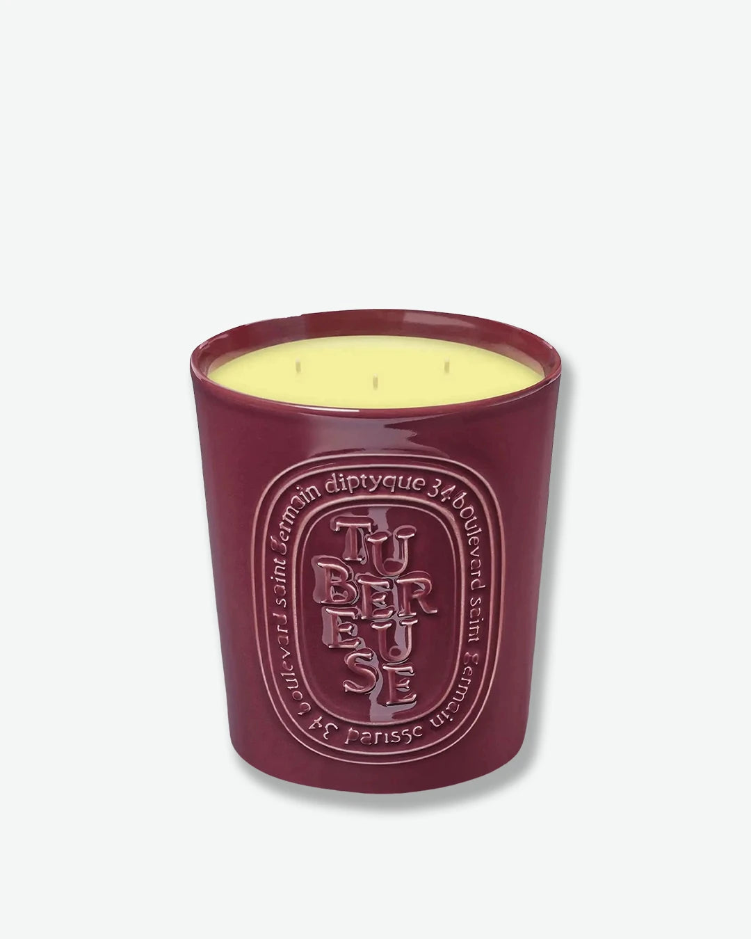 Diptyque candle in a red container on a white background