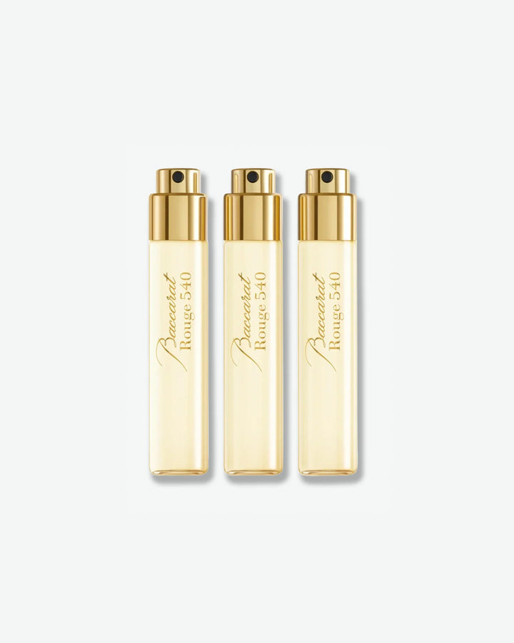 Three gold perfume bottles and their packaging with 'Maison Francis Kurkdjian' branding on a white background.