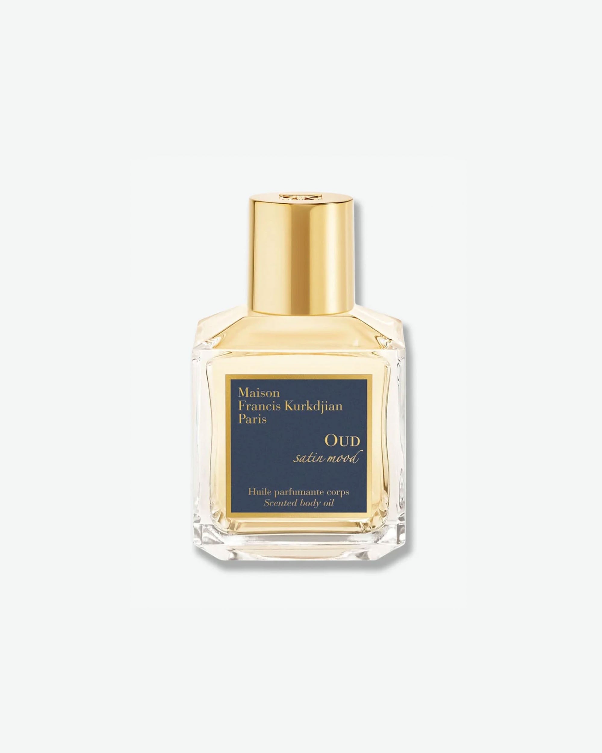 Front view of a square clear glass bottle with a gold cap containing Maison Francis Kurkdjian Paris "OUD satin mood" Scented body oil (Huile parfumante corps), featuring a dark blue and gold label.