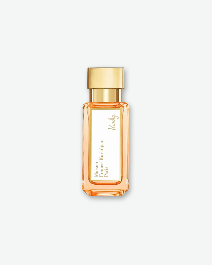 Direct front view of the slender, travel-sized Maison Francis Kurkdjian Paris "Kurky" Eau de Parfum bottle, featuring a rectangular clear glass body, peach-colored fragrance, a white label with gold borders, and a polished gold cap.