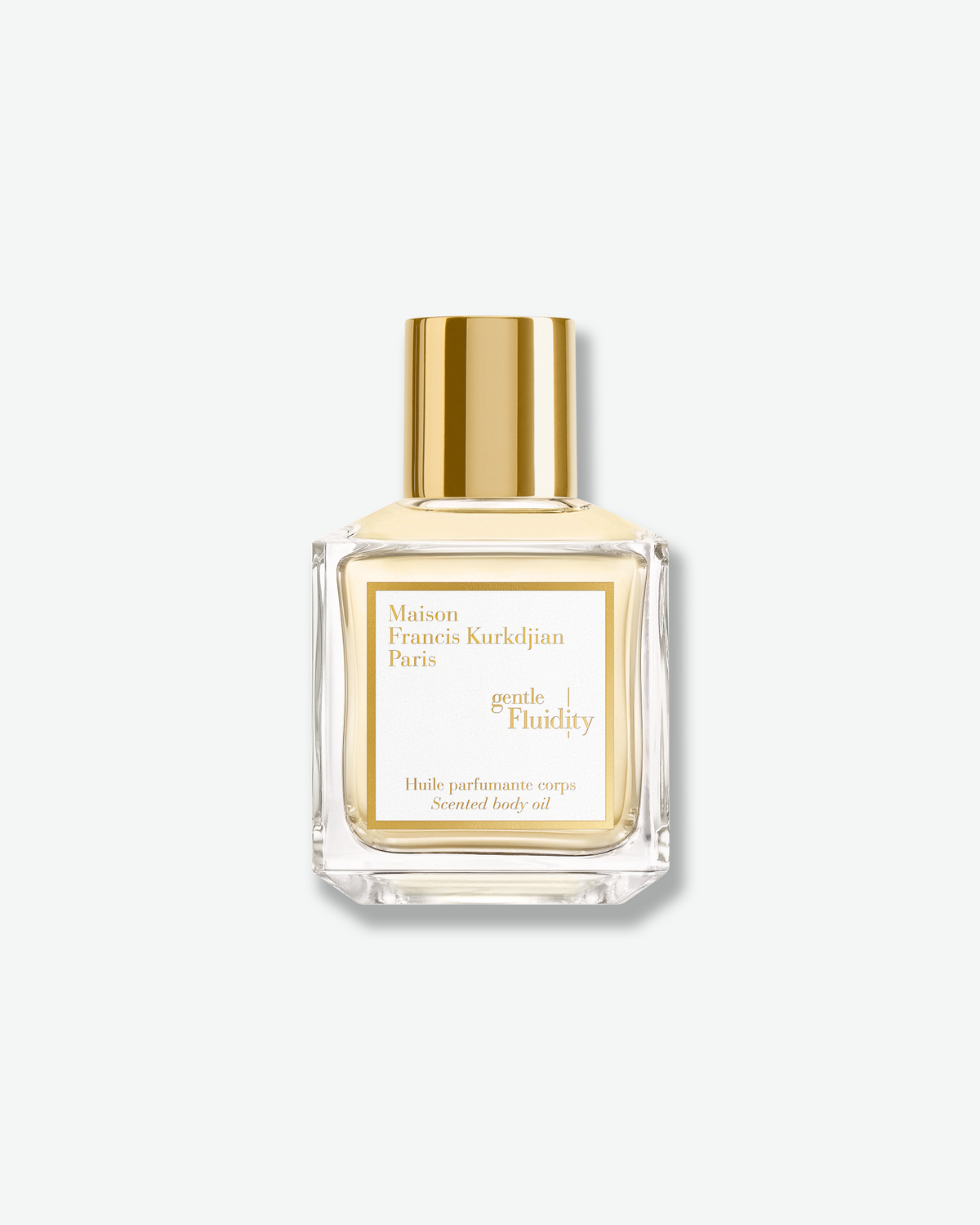 Maison Francis Kurkdjian Gentle Fluidity Scented Body Oil in a clear glass bottle with pale golden oil, white-and-gold label, and polished gold cap.