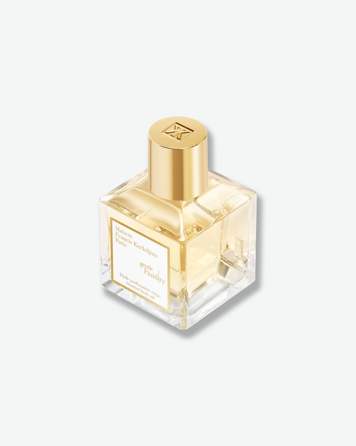Angled close-up of the Maison Francis Kurkdjian Gentle Fluidity Scented Body Oil, highlighting the clear glass bottle, golden oil, and signature gold cap.