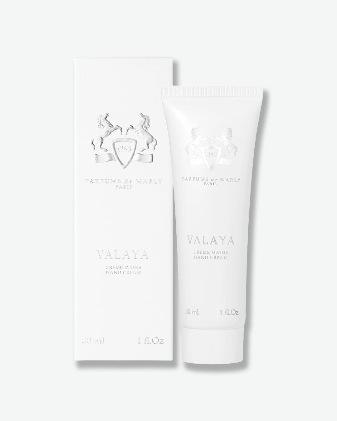 A white squeeze tube of Valaya Hand Cream standing next to its matching white rectangular box, both featuring silver-gray branding and text on a clean white background.