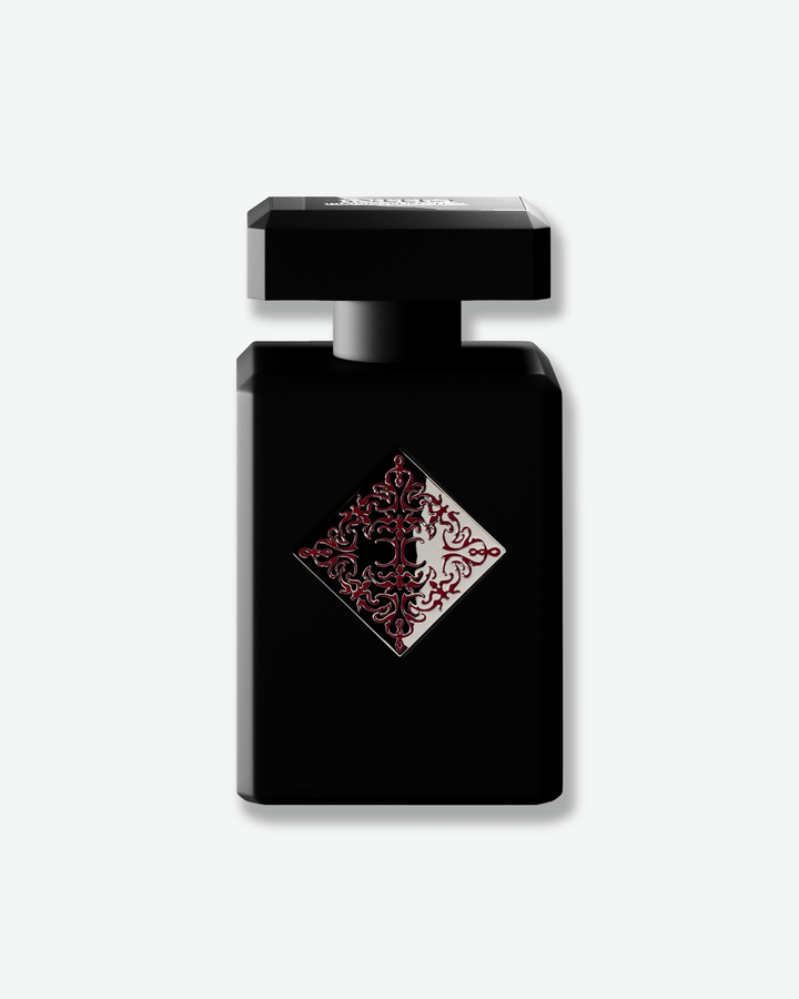 Black perfume bottle with decorative label on a white background