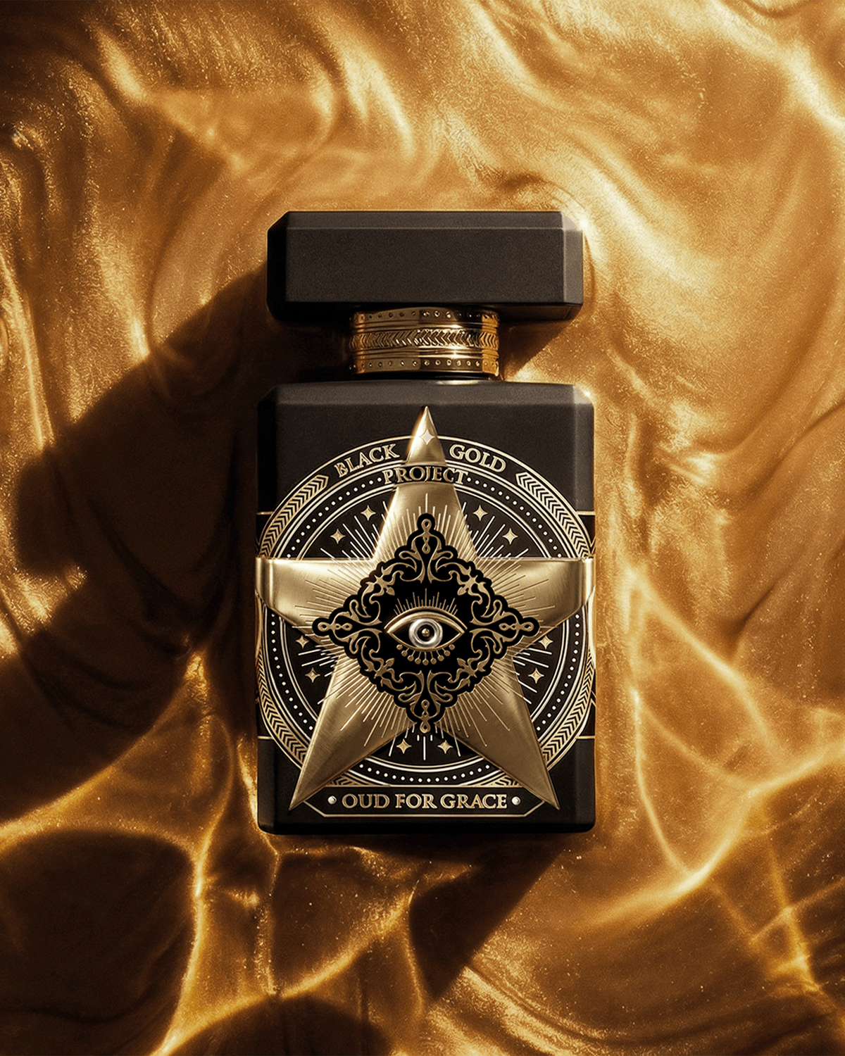 Initio Oud for Greatness Black Gold Project fragrance bottle resting on draped metallic gold fabric.