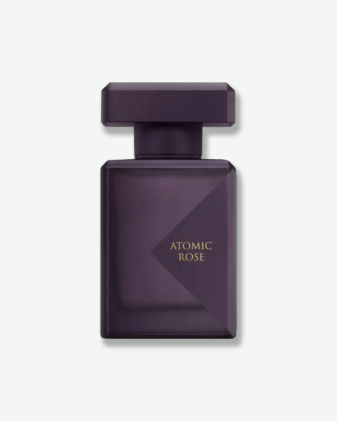 Dark purple perfume bottle labeled 'Atomic Rose' on a light gray background