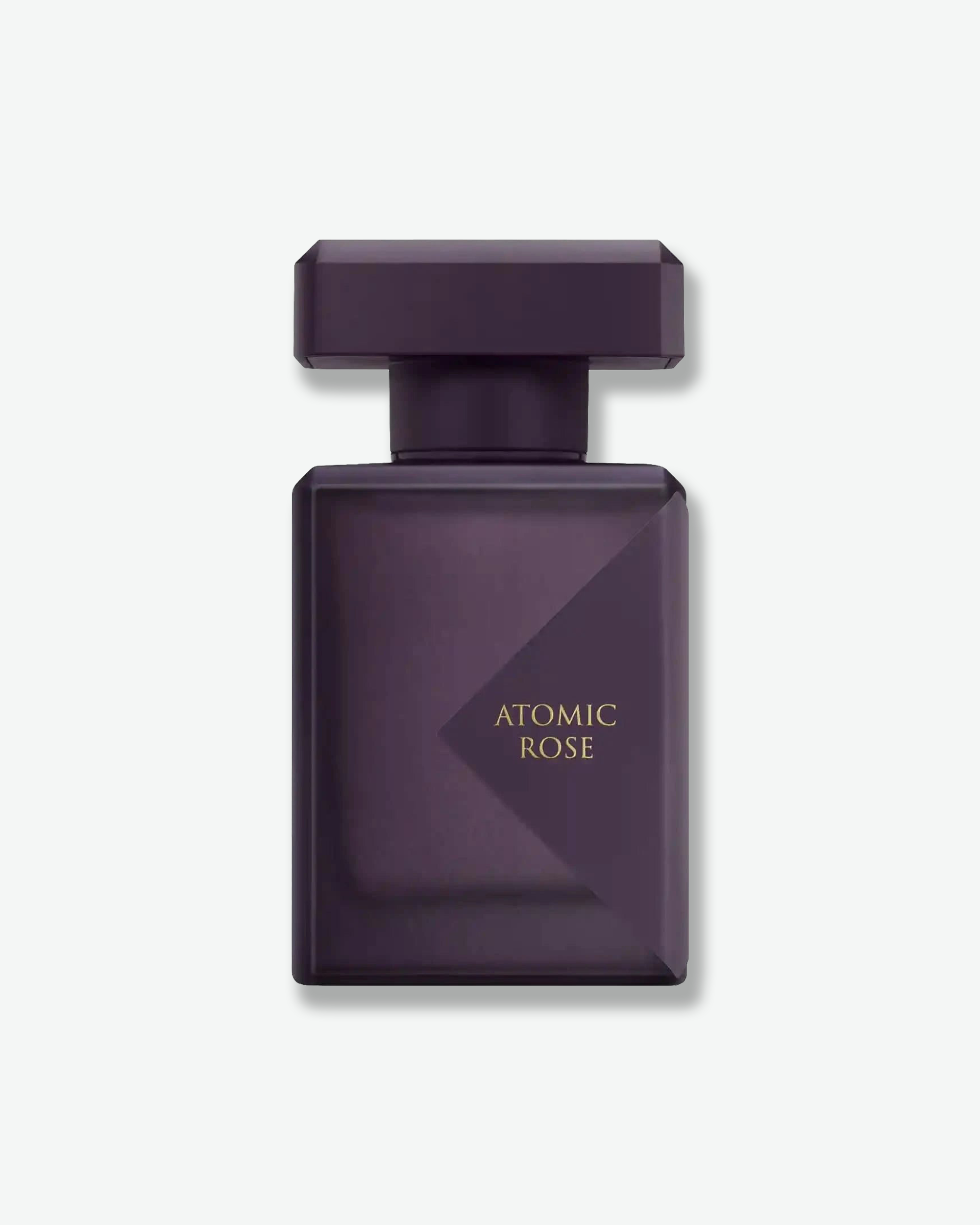 Dark purple perfume bottle labeled 'Atomic Rose' on a light gray background