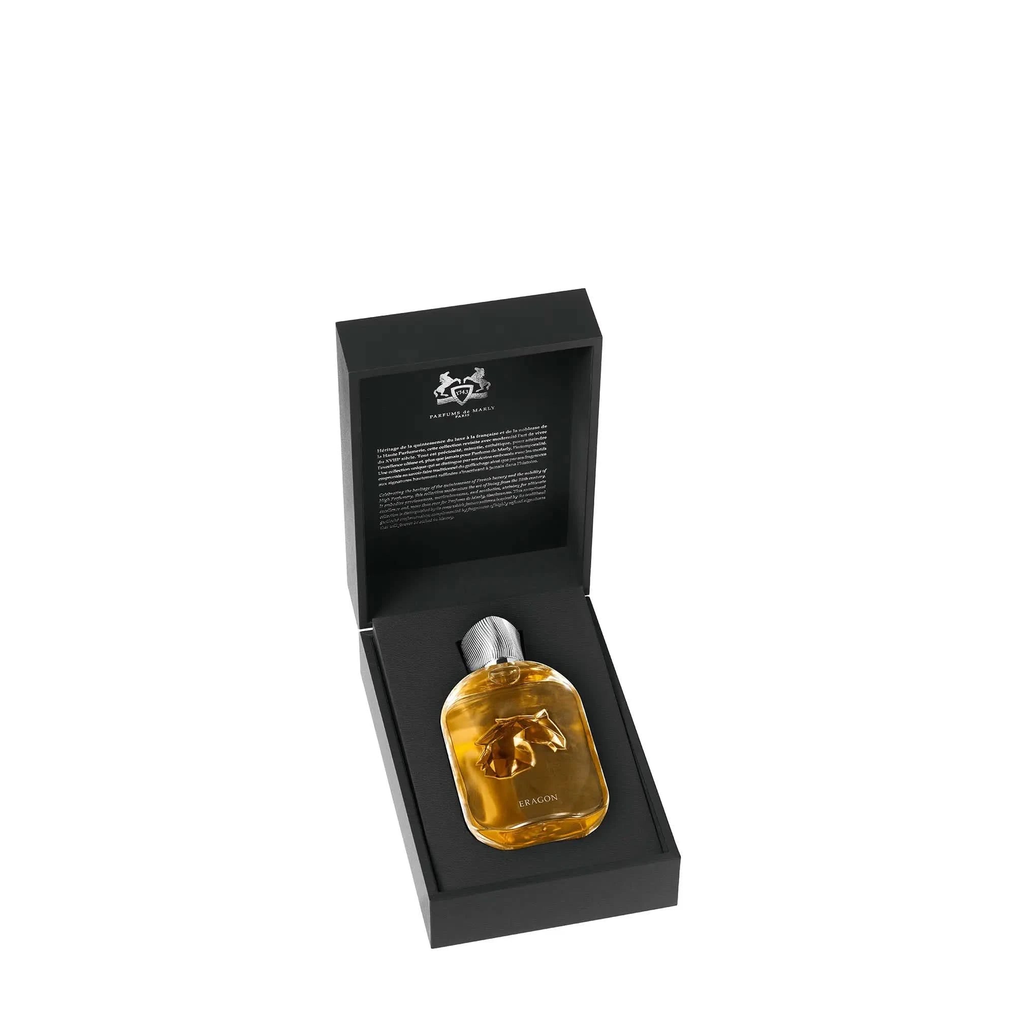 Perfume bottle with gold cap in a black box on a white background
