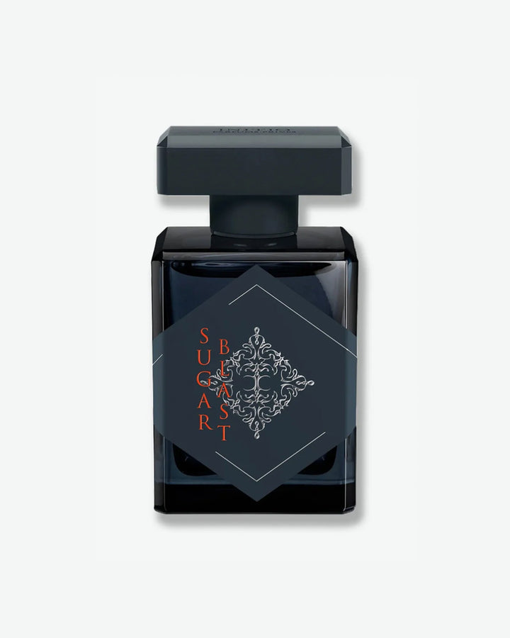 Initio Parfums Privés Sugar Blast Eau de Parfum in a sleek, square black bottle featuring a large charcoal grey diamond label with an intricate silver emblem and bold orange lettering, isolated on a light grey background.