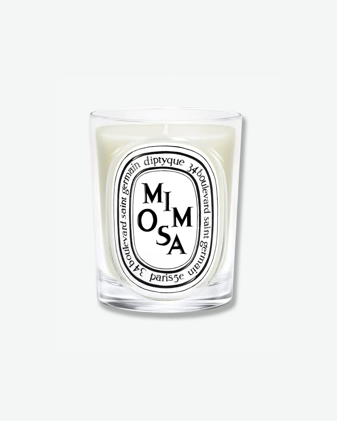 Diptyque Mimosa scented candle in a classic clear glass jar featuring the signature white oval logo with black lettering, isolated on a light grey background.