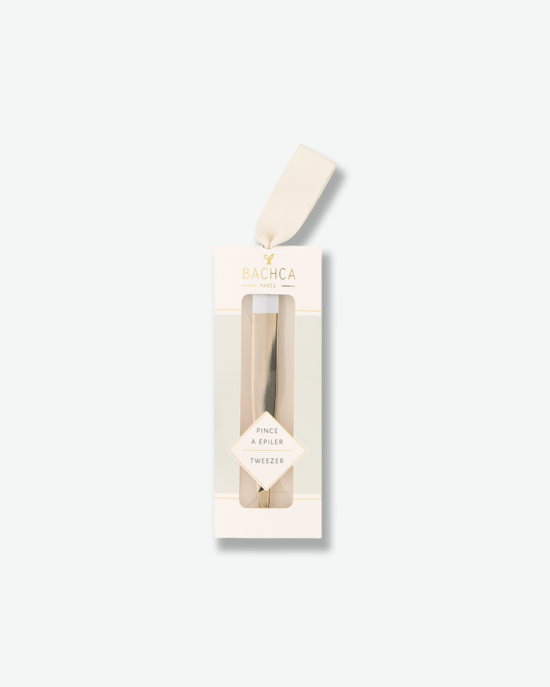 Luxury gold and white slanted tweezers in elegant cream-colored retail packaging on a solid white background.