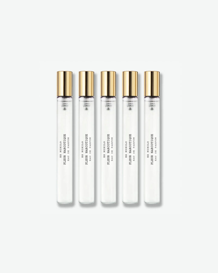 A set of five identical Ex Nihilo Fleur Narcotique Eau de Parfum travel spray vials with clear glass bodies and gold caps, lined up vertically against a light grey background.