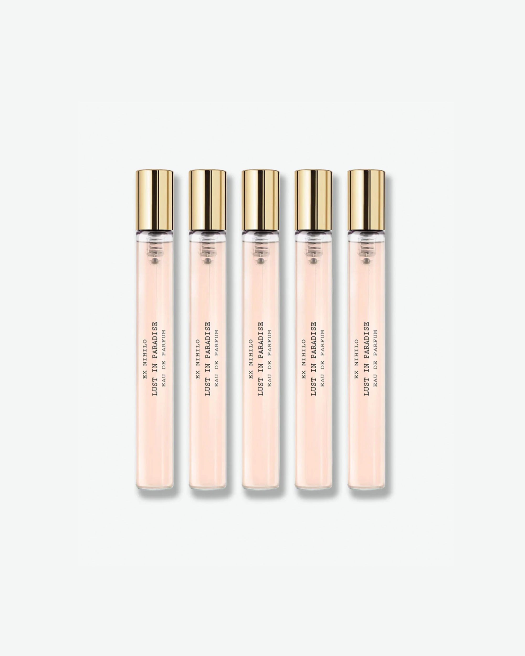A set of five identical Ex Nihilo Lust in Paradise Eau de Parfum travel spray vials showing a light pink liquid formula inside clear glass tubes with gold caps, isolated on a light grey background.