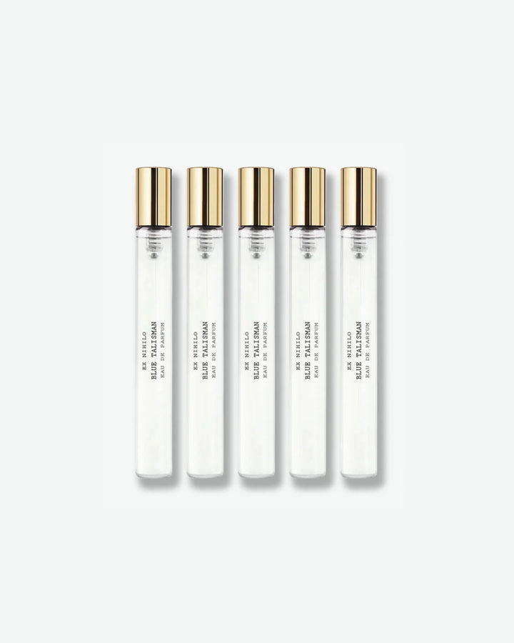 A set of five identical Ex Nihilo Blue Talisman Eau de Parfum travel spray vials with clear glass bodies and gold caps, arranged vertically against a light grey background.