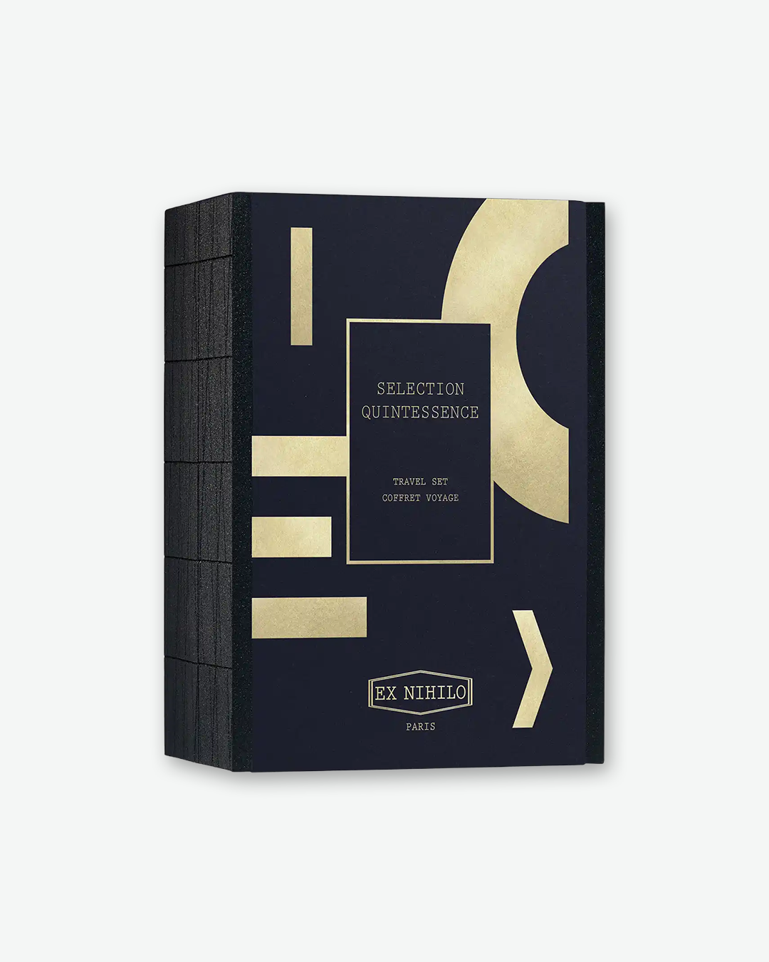 A dark navy or black textured rectangular gift box for the EX NIHILO "Selection Quintessence" travel set. The front cover features abstract geometric patterns in metallic gold, including rectangles and a large crescent curve. A central black label with a gold border reads "SELECTION QUINTESSENCE - TRAVEL SET - COFFRET VOYAGE," with the "EX NIHILO PARIS" logo at the bottom.