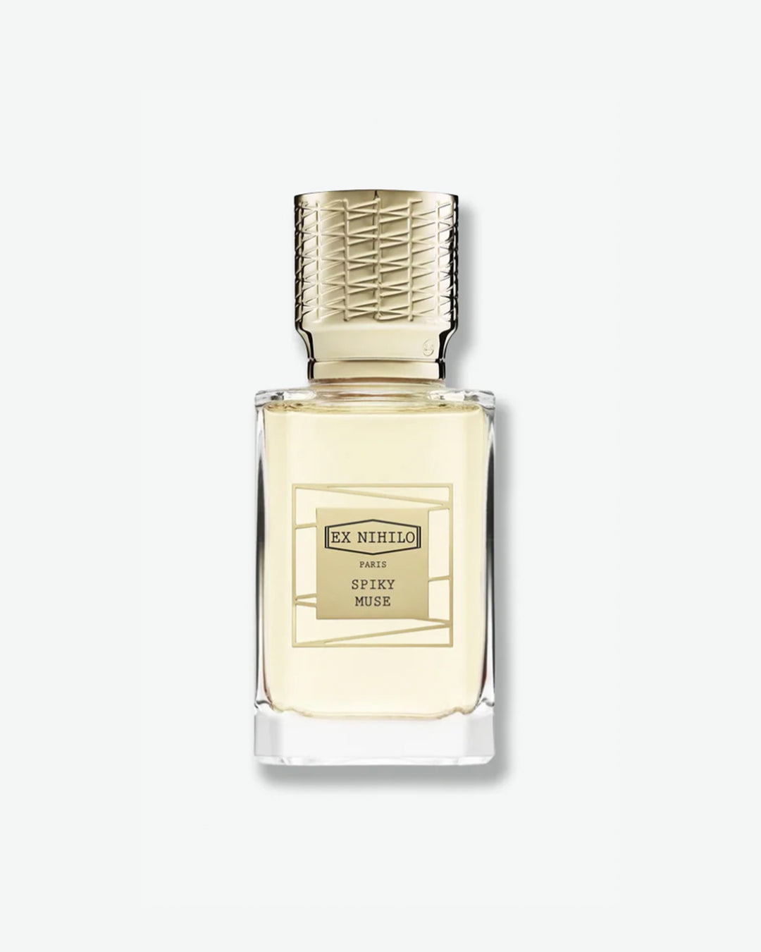 Ex Nihilo Spiky Muse Eau de Parfum in a heavy clear glass bottle showcasing a pale yellow liquid, topped with an intricately engraved gold cap and a matching gold geometric label, isolated on a light grey background.