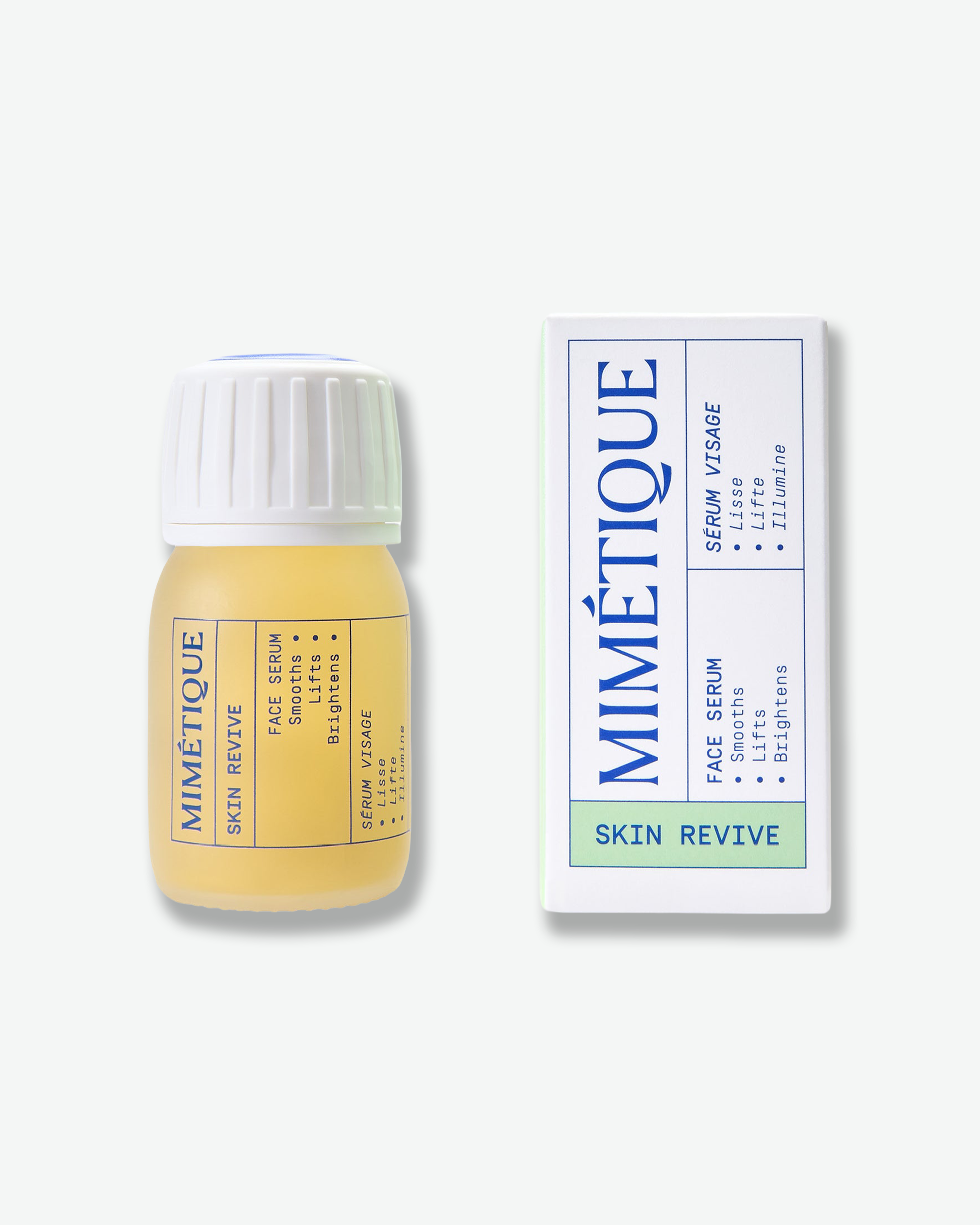 A small bottle of Mimétique Skin Revive serum with pale yellow liquid and a white cap, shown next to its white product box with blue text and a light green band, on a clean off-white background.