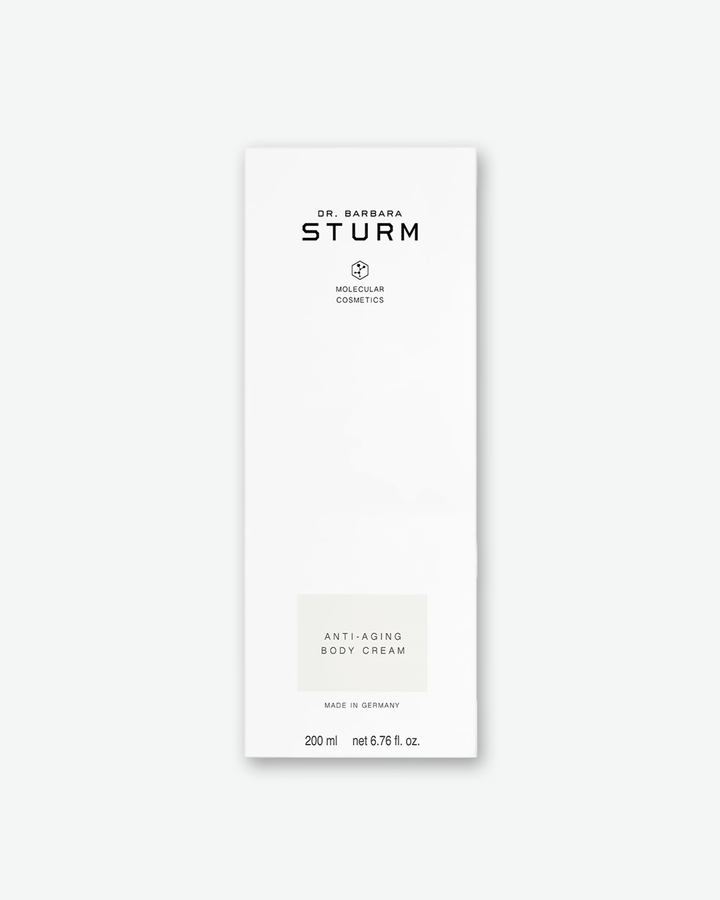 A product shot of the tall, white cardboard box for the Dr. Barbara Sturm Anti-Aging Body Cream, centered against a light gray background. It displays standard black branding with a light gray rectangular area accenting the product name. The bottom lists a volume of "200 ml net 6.76 fl. oz."