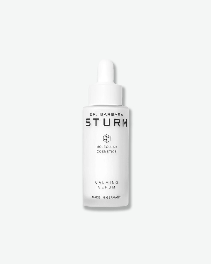 A product shot of a Dr. Barbara Sturm Calming Serum bottle, centered against a light gray background. The bottle is made of frosted white glass and is topped with a white rubber dropper bulb assembly. The clean black text on the front reads "DR. BARBARA STURM", the molecular hexagon logo, "MOLECULAR COSMETICS", "CALMING SERUM", and "MADE IN GERMANY".