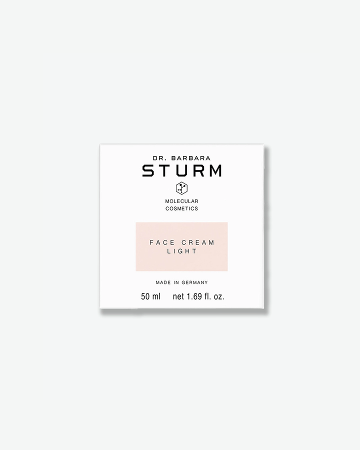 A product shot of the white square cardboard box for Dr. Barbara Sturm Face Cream Light, centered against a light gray background. It displays the brand text and logo, with a soft, pale pink rectangular block highlighting the words "FACE CREAM LIGHT". The bottom indicates "50 ml net 1.69 fl. oz."