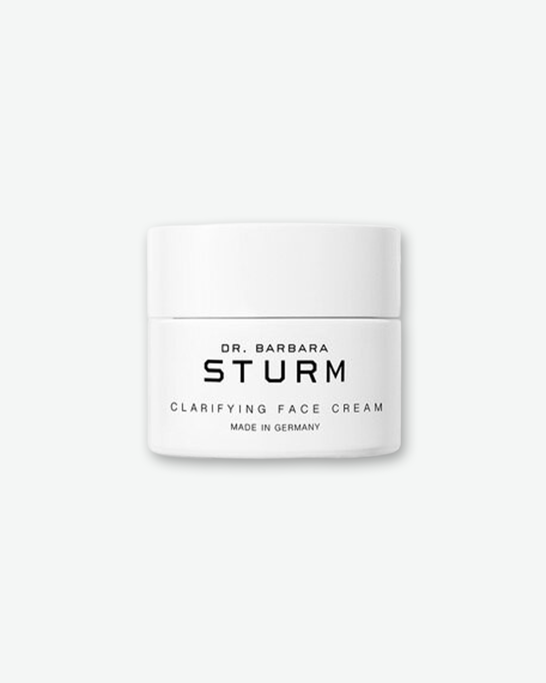 A product shot of a Dr. Barbara Sturm Clarifying Face Cream jar, centered against a light gray background. The smooth white cylindrical jar has a matching flat cap and features minimalist black branding on the front reading "CLARIFYING FACE CREAM" and "MADE IN GERMANY".