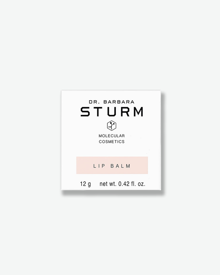 Front view of a square white cardboard outer packaging box for Dr. Barbara Sturm Molecular Cosmetics Lip Balm. The minimalist box features the brand name, a molecular icon, the product title on a soft pastel pink strip, and product weight details printed in black.