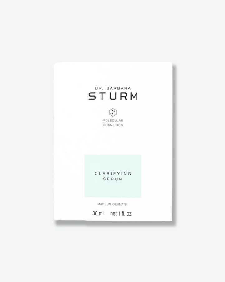 A product shot of the white cardboard box for Dr. Barbara Sturm Clarifying Serum, centered against a light gray background. The minimalist outer packaging features clean black branding text and a small molecular hexagon logo. A pastel, mint-green rectangle highlights the product name "CLARIFYING SERUM" in the lower center. The bottom notation reads "MADE IN GERMANY" above the volume "30 ml net 1 fl. oz."