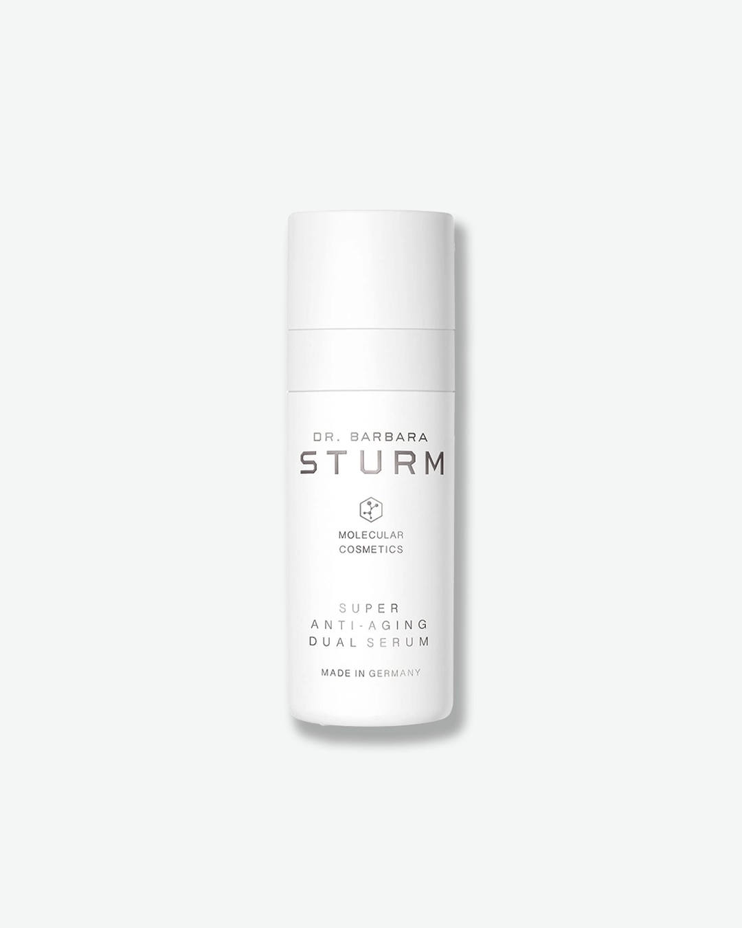 A product shot of a Dr. Barbara Sturm Super Anti-Aging Dual Serum bottle, centered against a light gray background. The tall, cylindrical white bottle features a matching opaque pump cap. The minimalist black text on the front reads "DR. BARBARA STURM", the molecular hexagon logo, "MOLECULAR COSMETICS", "SUPER ANTI-AGING DUAL SERUM", and "MADE IN GERMANY".