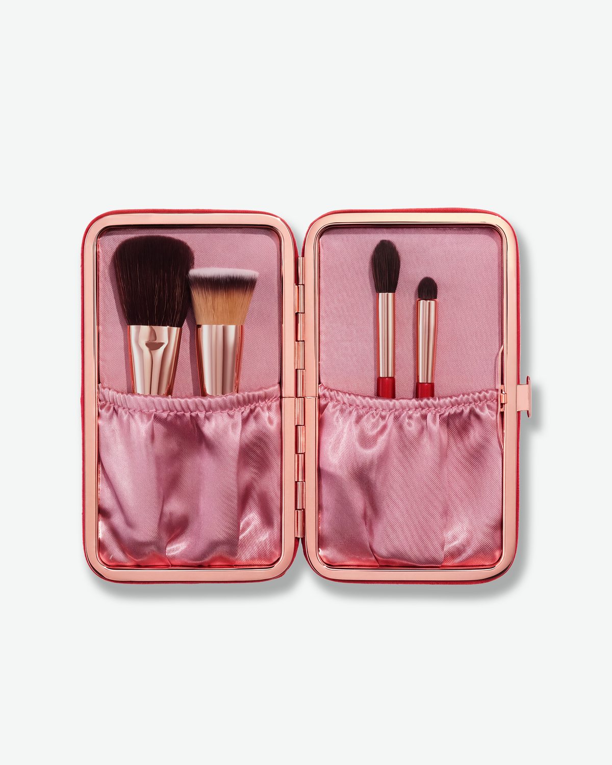 Open Charlotte Tilbury brush case showing four mini brushes in a pink satin interior.