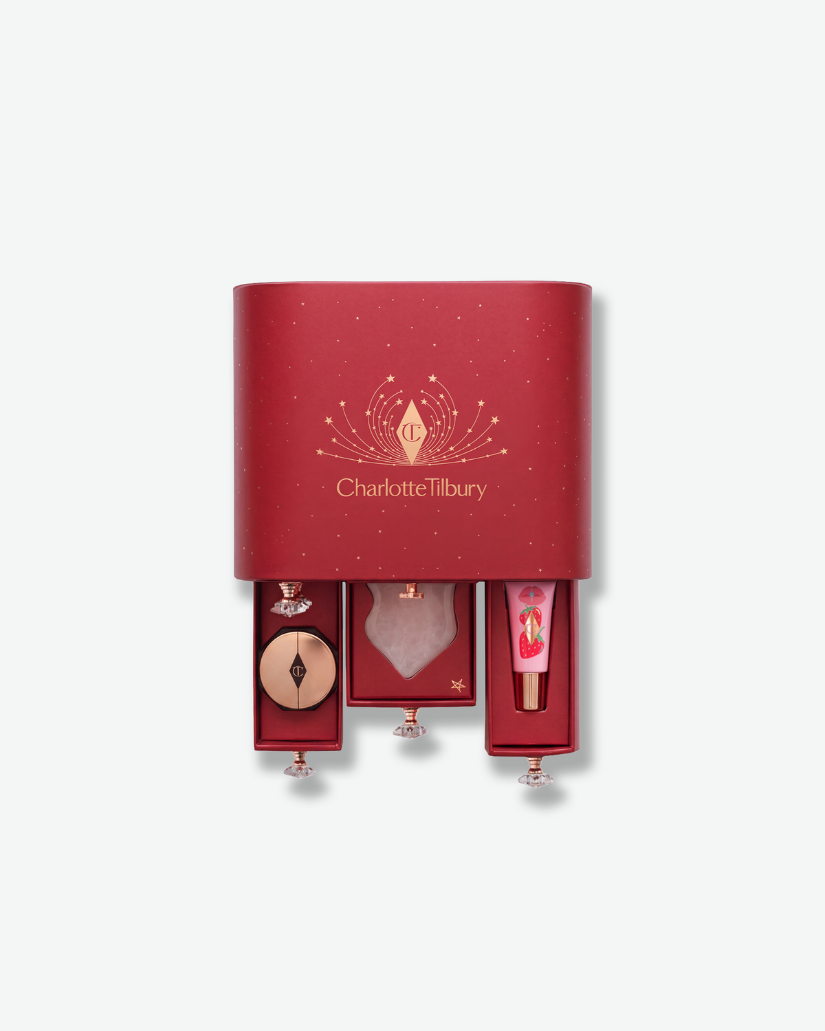 Charlotte Tilbury holiday advent calendar shown partially open with beauty products revealed inside its red drawers.