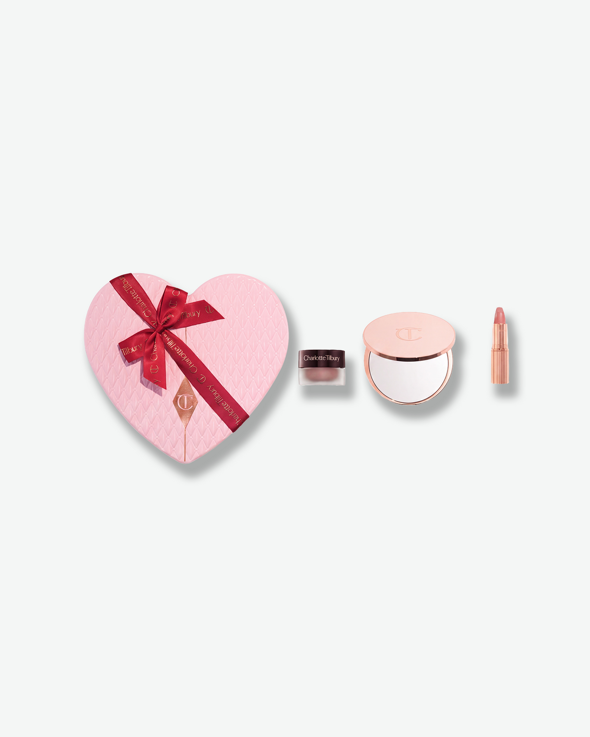 Charlotte Tilbury Pillow Talk gift set with heart-shaped pink box, compact mirror, lip product, and beauty pot.