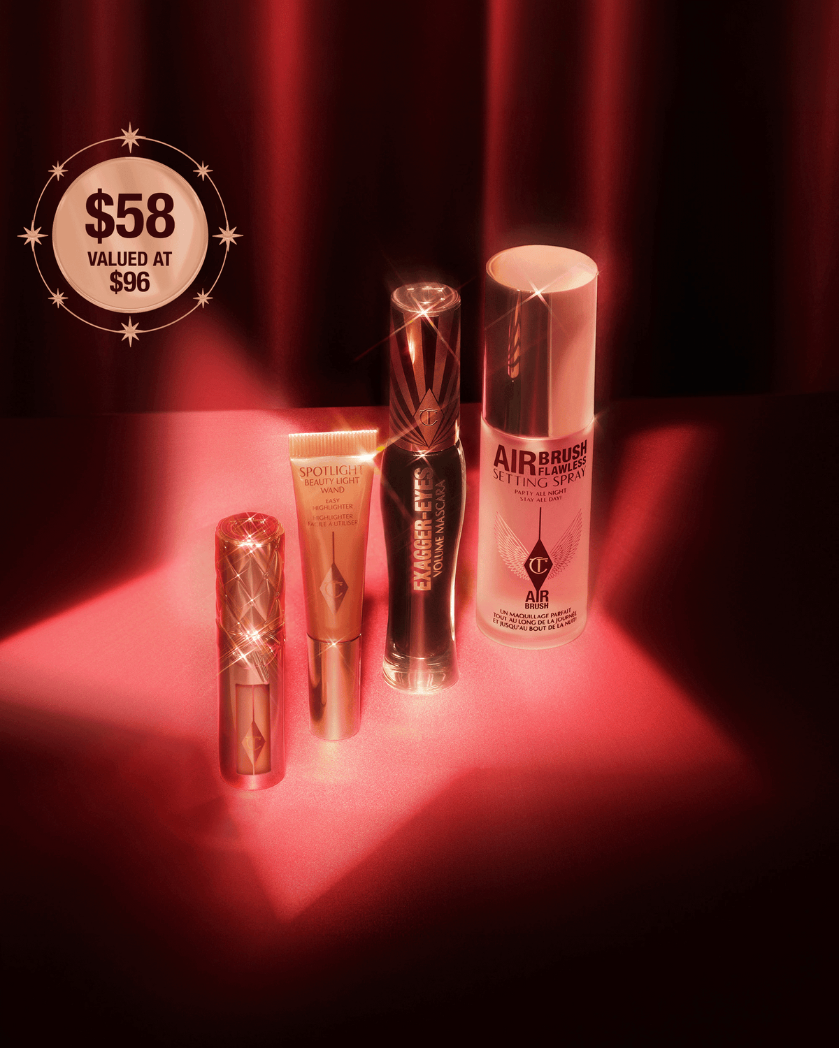 Charlotte Tilbury Iconic Hollywood Beauty Secrets products displayed against red velvet, including lip color, Beauty Light Wand, Exagger-Eyes Mascara, and Airbrush Flawless Setting Spray.