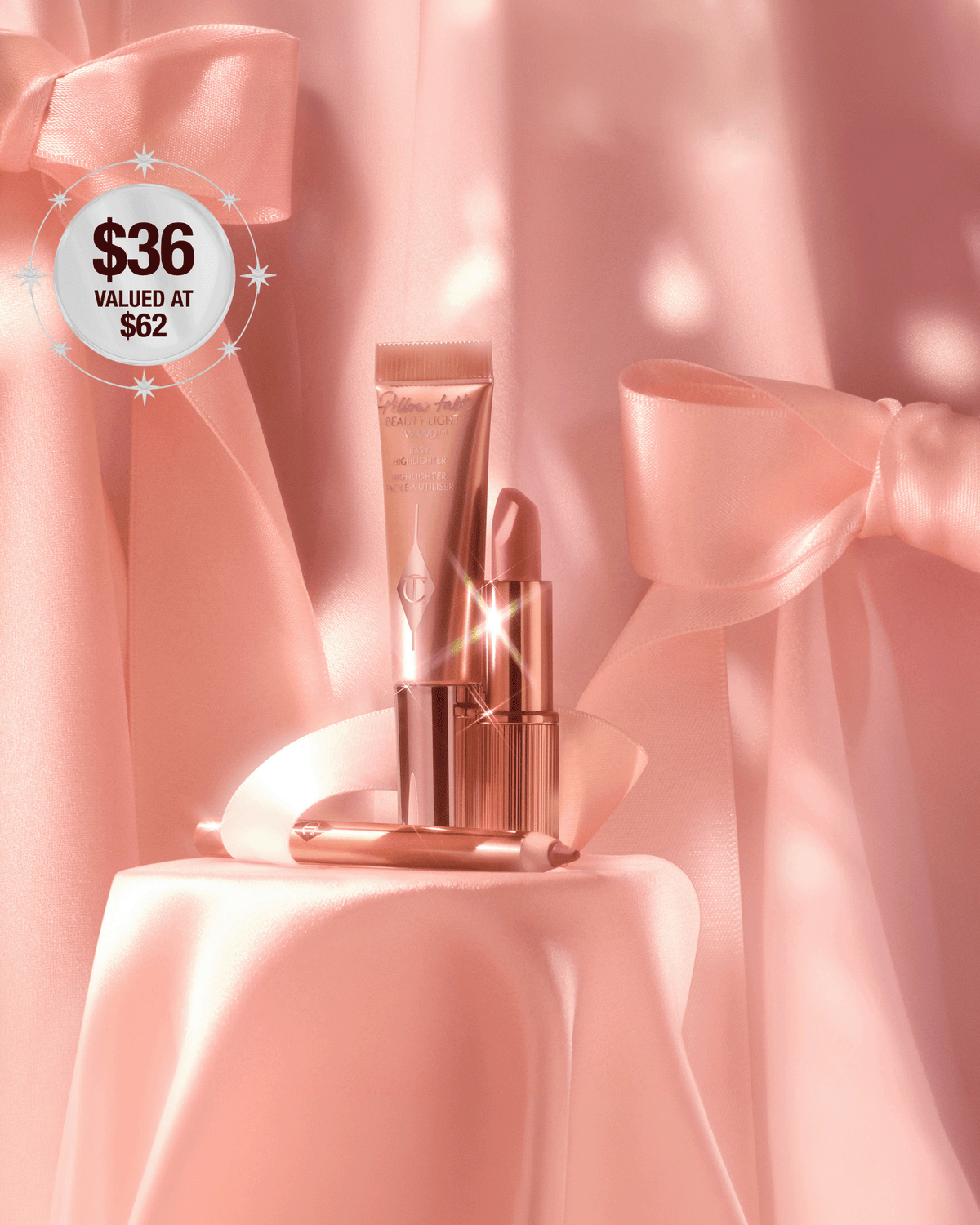 Charlotte Tilbury Pillow Talk Iconic Lip + Cheek Kit styled on blush pink satin with oversized bows, featuring the lipstick, Beauty Light Wand, and Lip Cheat liner.