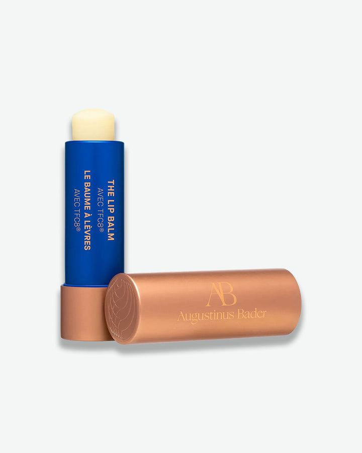 Lip balm with blue container and bronze applicator on a white background