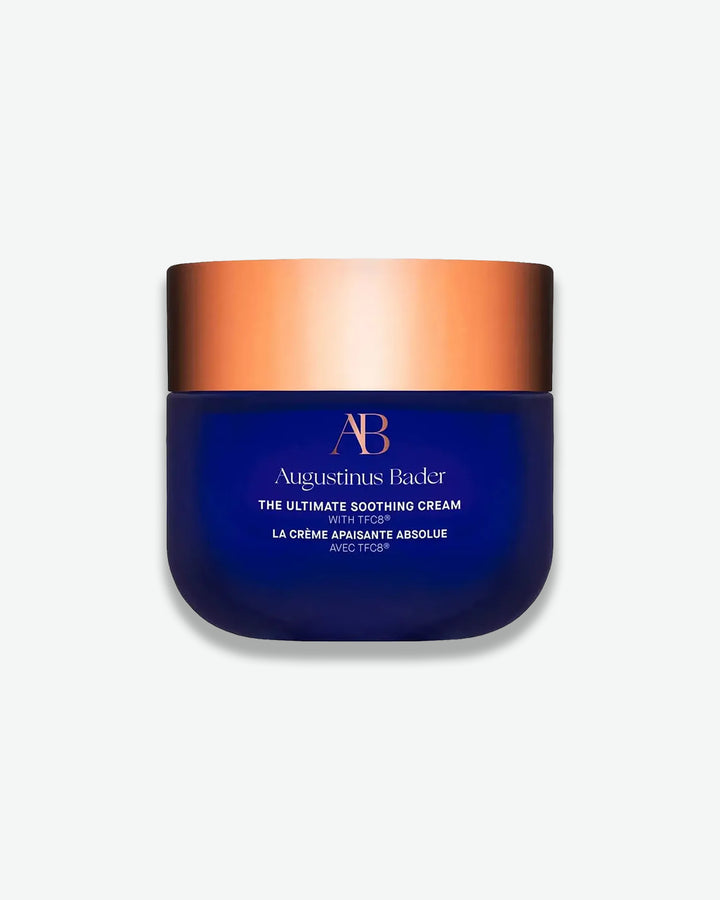 Blue jar with bronze lid of Augustinus Bader cream on a white background