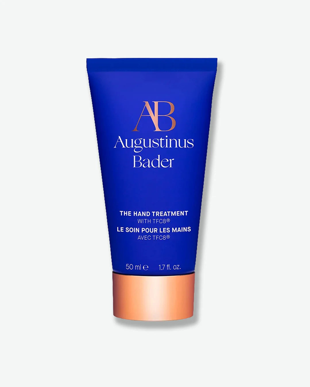 Blue Augustinus Bader The Hand Treatment tube with a copper cap, centered against a light grey background.