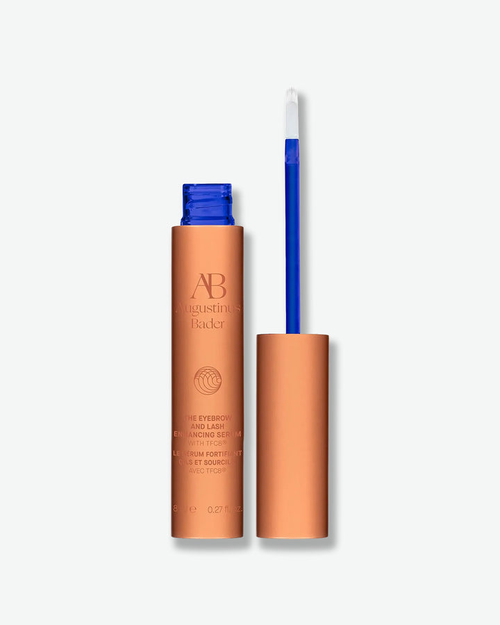 Bronze-colored cosmetic tube with blue cap and applicator on a white background