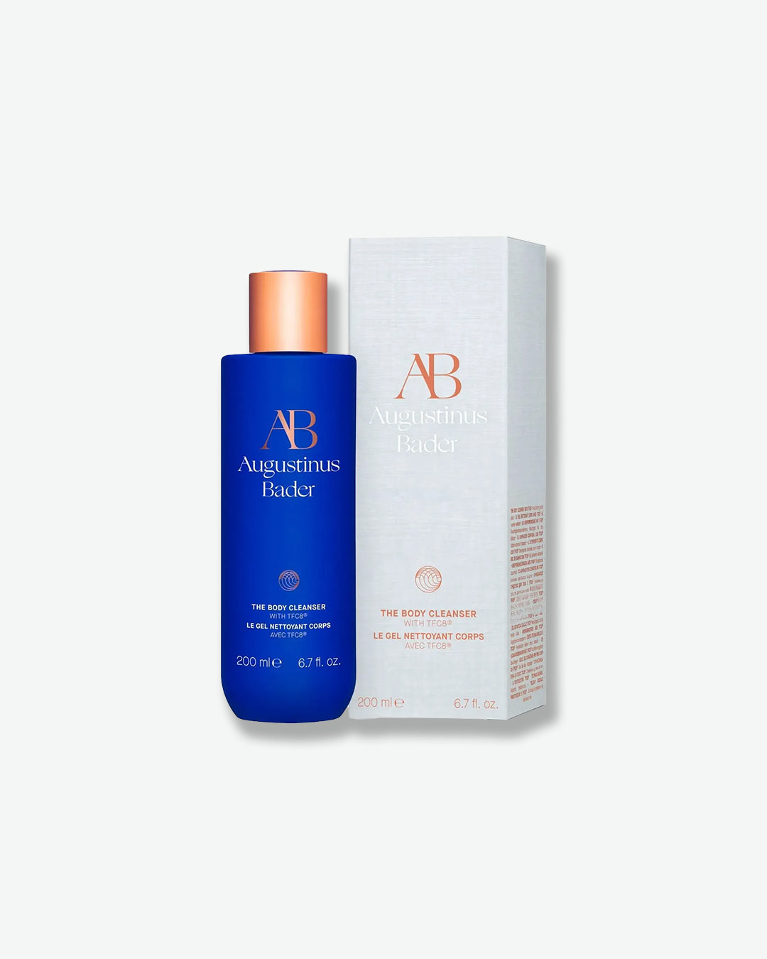Blue bottle and white box of Augustinus Bader skincare product on a white background