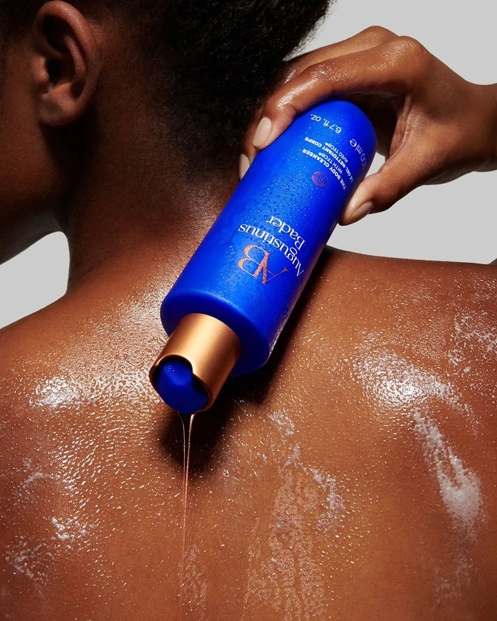 Person applying blue bottle of sunscreen to shoulder