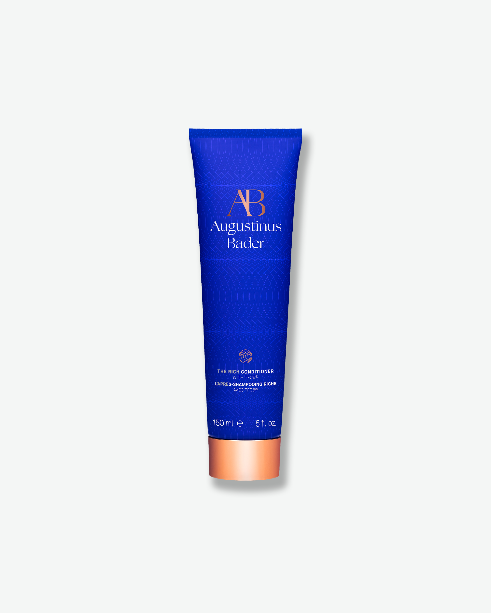 A bright blue squeeze tube of Augustinus Bader hair conditioner with a metallic copper cap, centered on a light gray background.