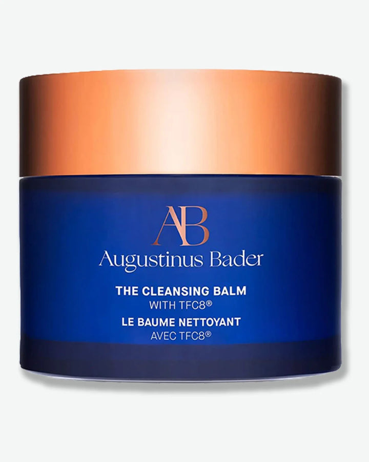 Augustinus Bader The Cleansing Balm jar with blue body and bronze lid design on a light grey background