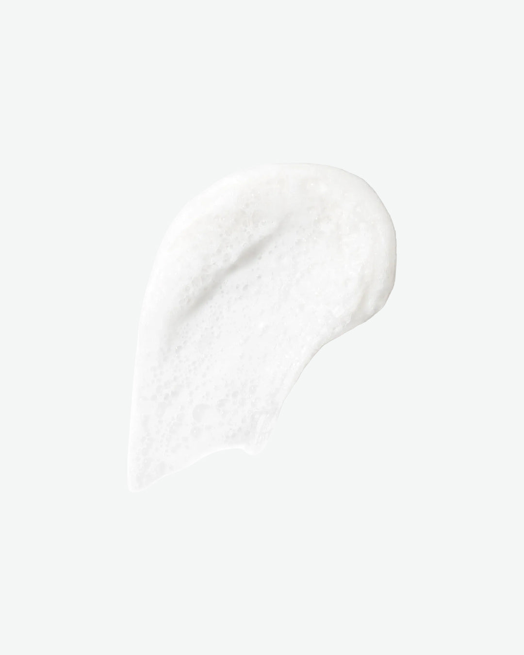 Close-up of white cream or lotion on a light gray background