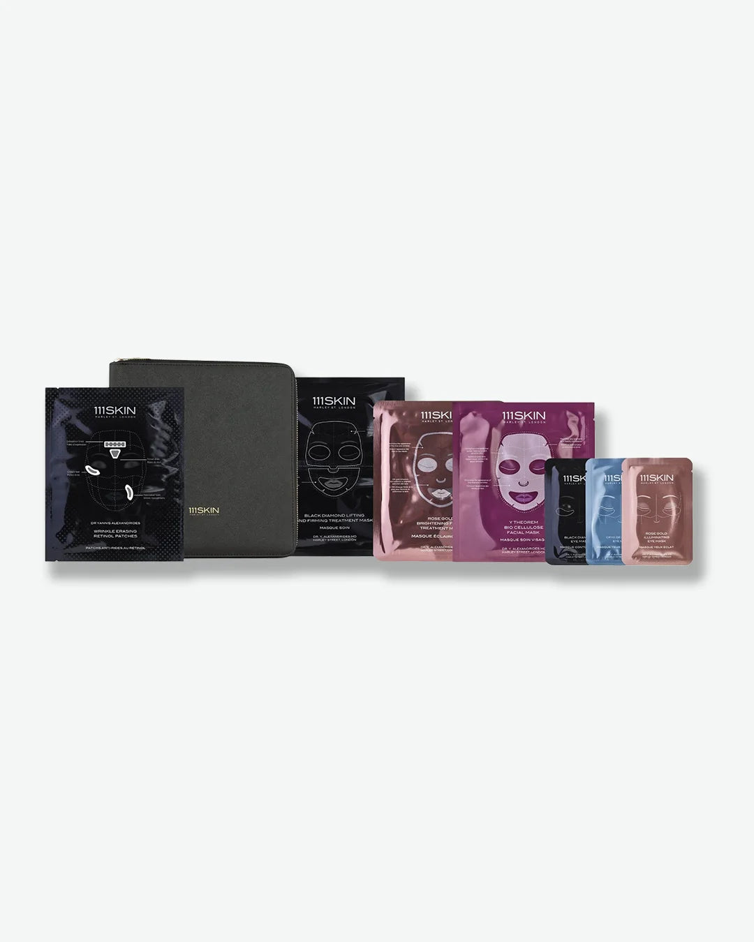 A skincare gift set by 111SKIN featuring a black zippered travel case alongside an assortment of face mask and eye mask sachets in black, rose gold, purple, and blue packaging.