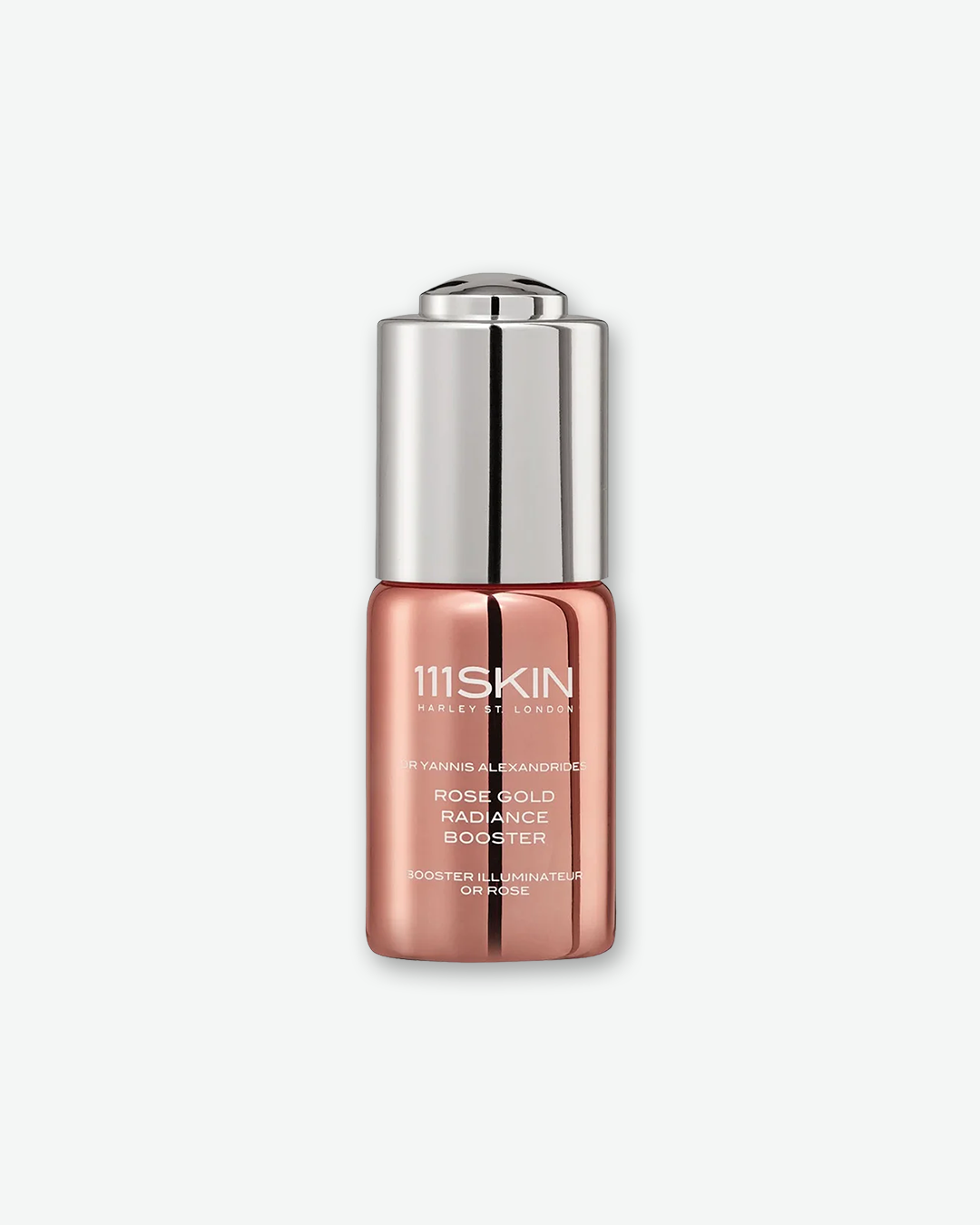 Front view of a 111SKIN Rose Gold Radiance Booster bottle against a plain gray background. The small, cylindrical container features a highly reflective, metallic rose gold glass base with white typography, capped with a sleek, polished silver metallic dropper assembly.